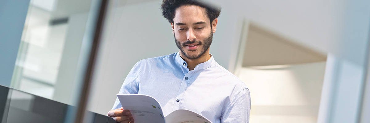 zoomed in image of a middle ages male, reading a booklet