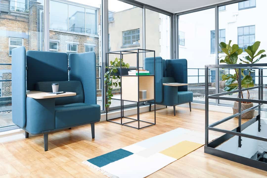 Blue smart armchairs in office environment with small desk attached to armrest