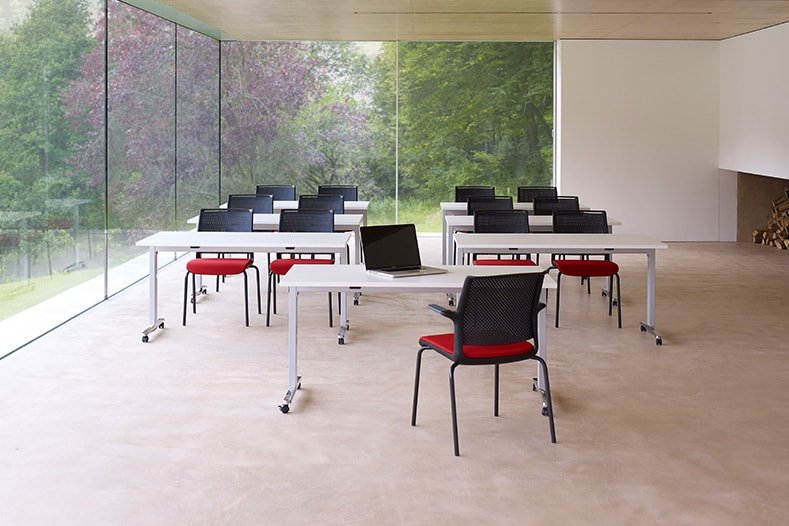 Modern classroom with white desks and red chairs and large glass panels